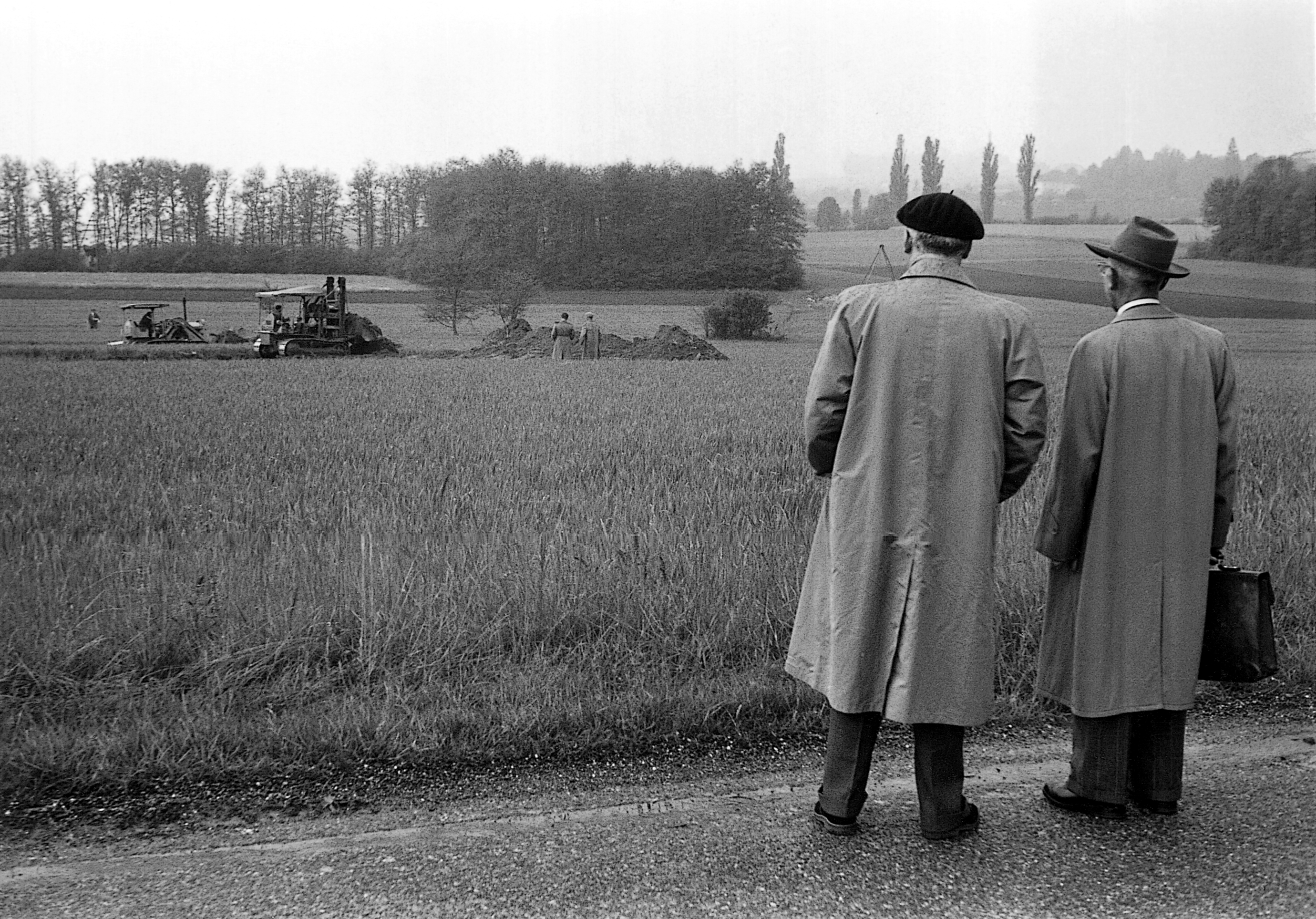 Foto del presidente dell’ancora provvisorio Consiglio del CERN, Robert Valeur, e di un rappresentante del Cantone di Ginevra, mentre guardano i primi lavori di costruzione del CERN, nella campagna di Meyrin, alle porte di Ginevra, il 17 Maggio del 1954