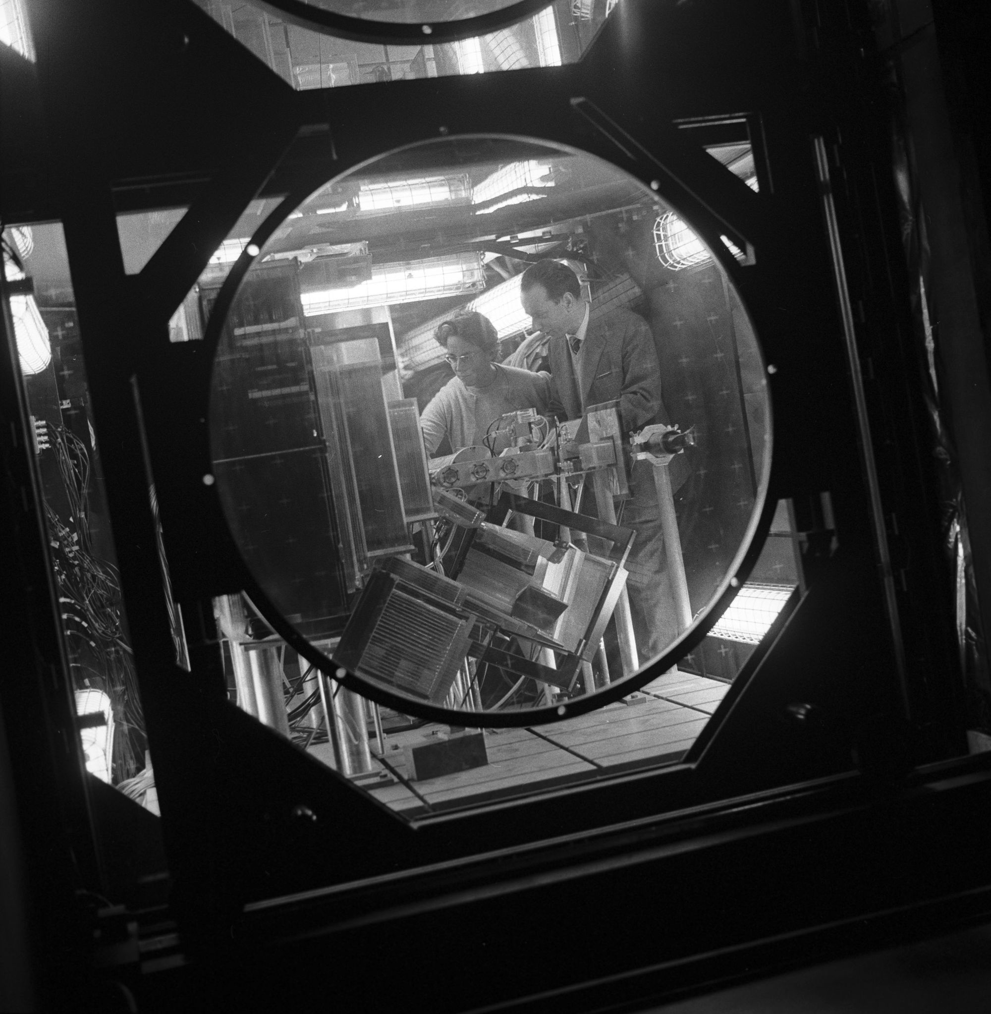 Foto di Maria e Giuseppe Fidecaro all’interno della camera a scintille sull’acceleratore "PS" del CERN, nel Novenbre del 1964, alla ricerca del decadimento della particella “pione” in una particella “muone” e in un neutrino.